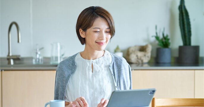 自宅のPCから派遣会社にWeb登録をしている女性のイメージ
