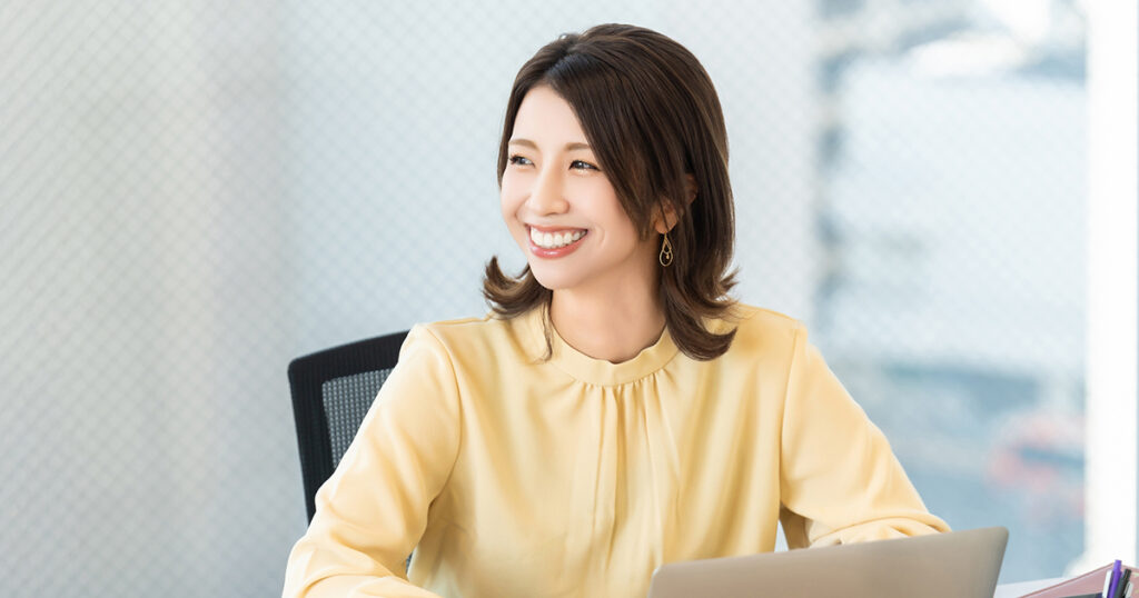 オフィスで笑顔で仕事をしている派遣社員のイメージ