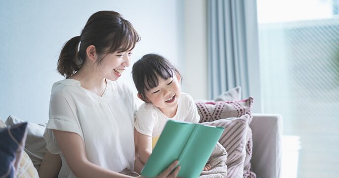 母親と幼い娘が家で団らんしているイメージ