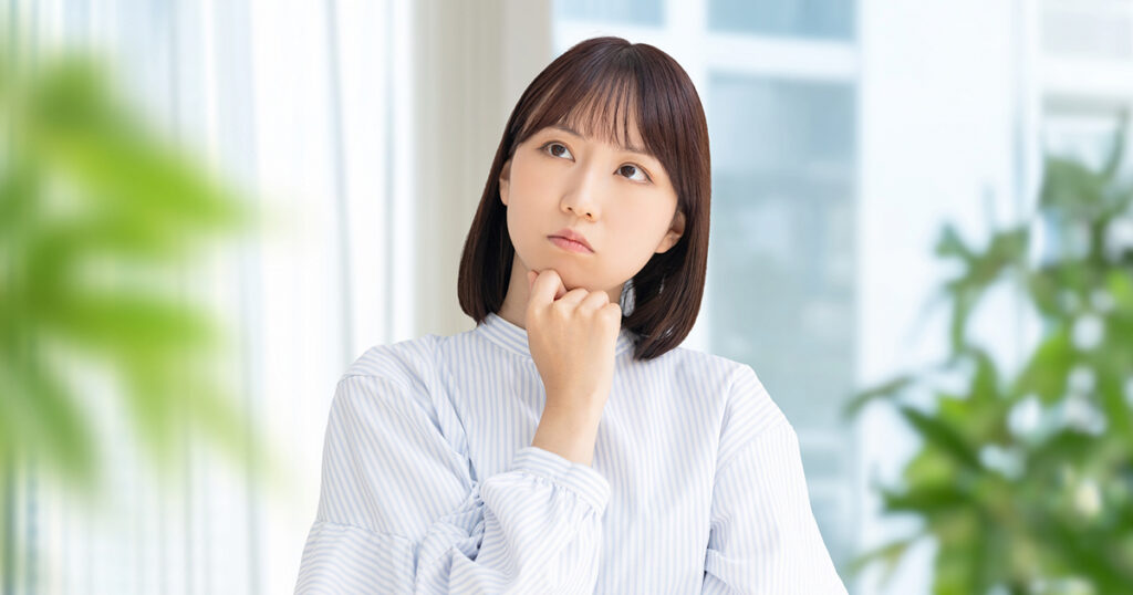 派遣社員の女性が、正社員と同じ福利厚生を受けられるのか悩んでいるイメージ