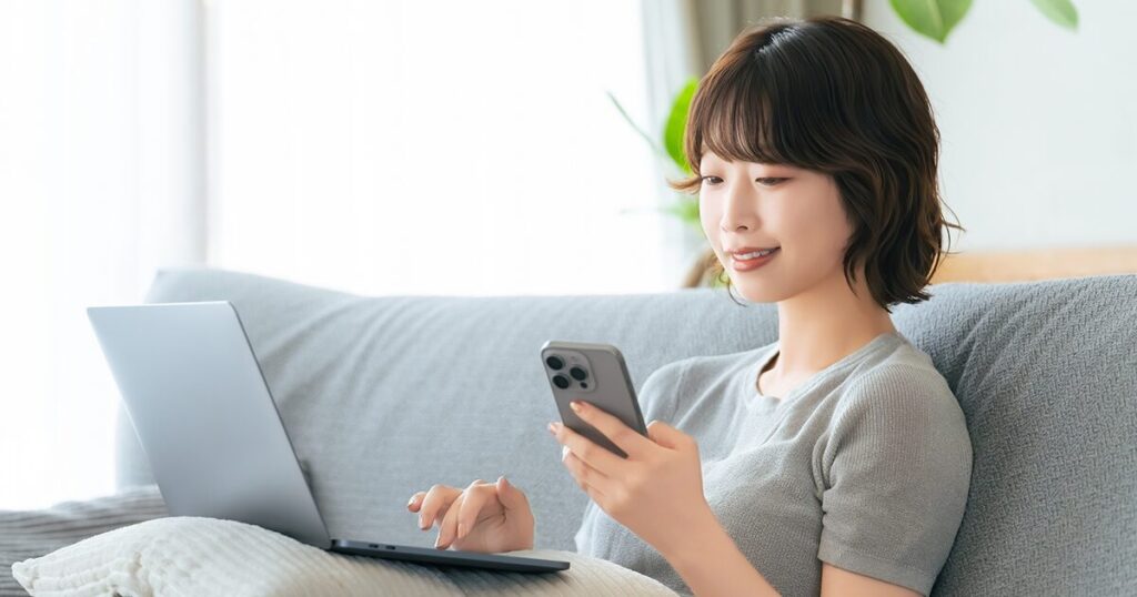 スマホとPCを使って求人情報を検索している女性のイメージ