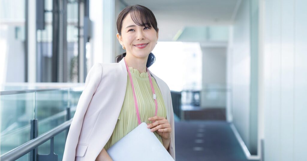 オフィスでにこやかに働く派遣スタッフの女性