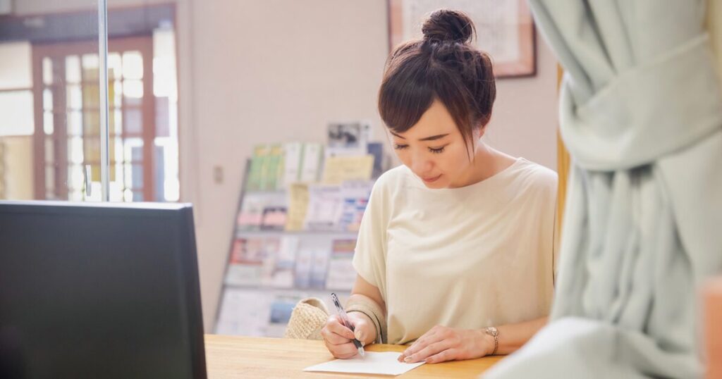 派遣社員が再就職手当の申請書類を記入しているイメージ