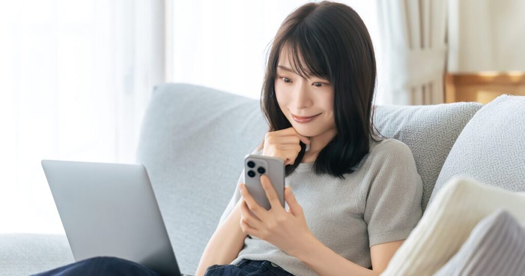 派遣の社会保険についてスマートフォンで情報を調べる女性のイメージ