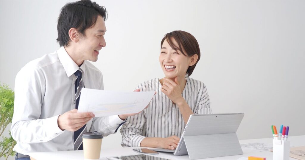 40代未経験から事務職で働き始めた女性が、同僚と楽しく業務をしているイメージ