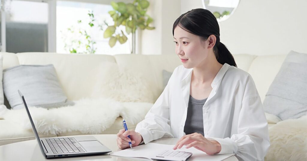 派遣の給与や手取り額を計算している女性のイメージ