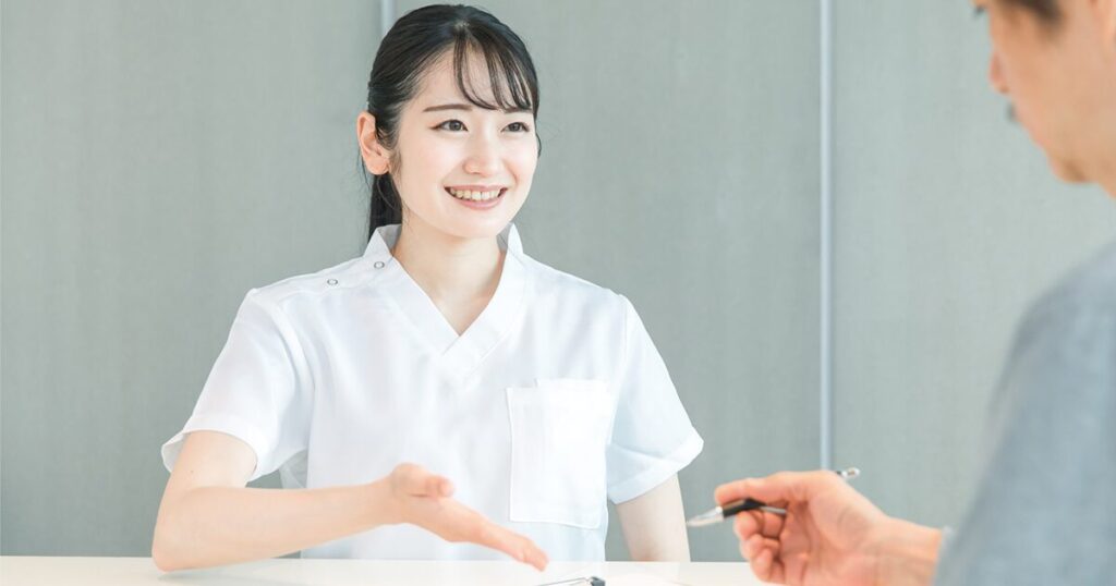 接客業から医療事務に転職し、クリニックで受付をしている女性のイメージ