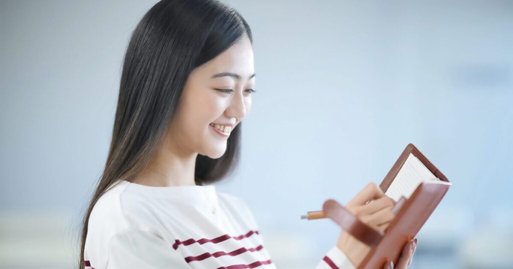 履歴書を書くにあたり、これまでの派遣の職歴を整理している女性のイメージ