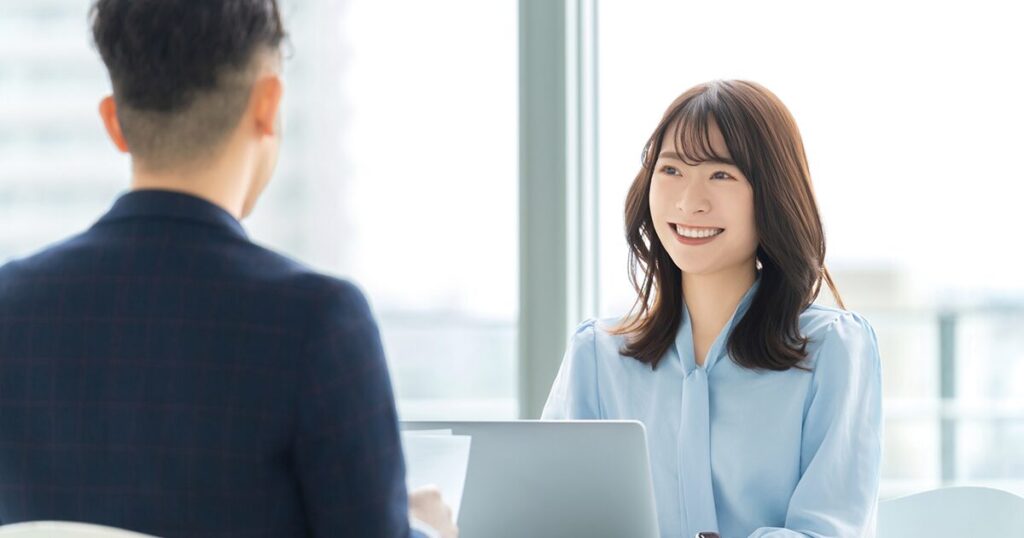 ひとり事務として上司とうまくコミュニケーションをとりながら仕事をする女性のイメージ