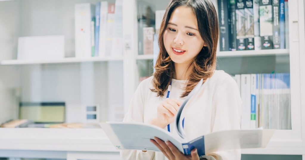 派遣の契約満了が会社都合になるか自己都合になるか、条件を確認している女性派遣社員のイメージ