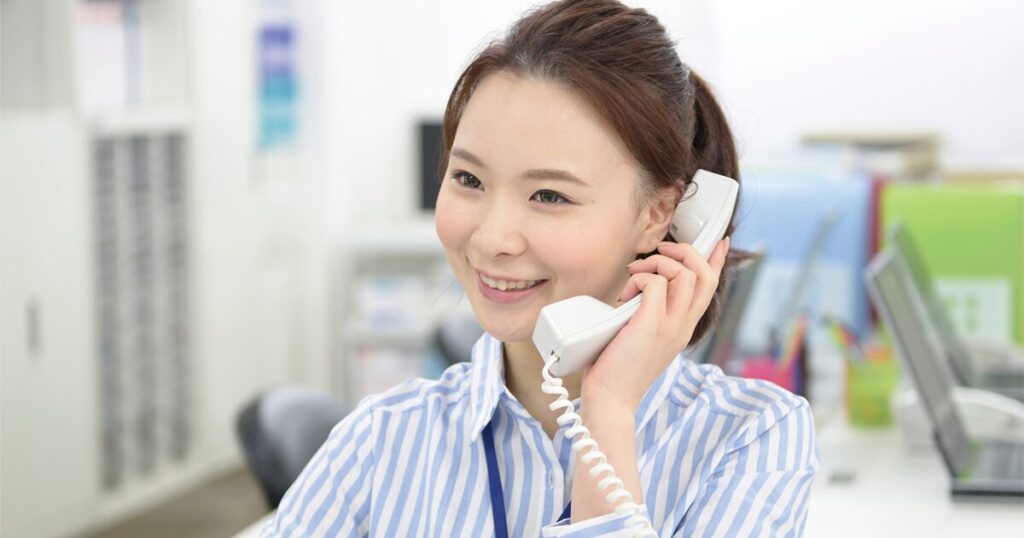 クッション言葉を使いながら電話応対をしている女性のイメージ