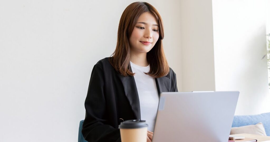 「了解しました」を使った例文を確認しながらビジネスメールを作成している女性のイメージ