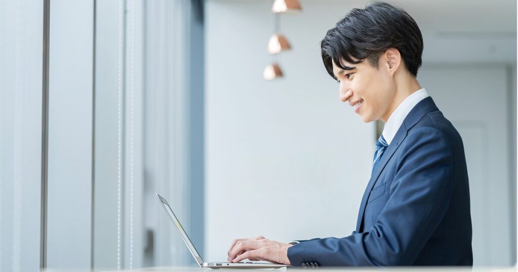 「ご教示ください」をより丁寧に言い換えてビジネスメールを作成している男性のイメージ