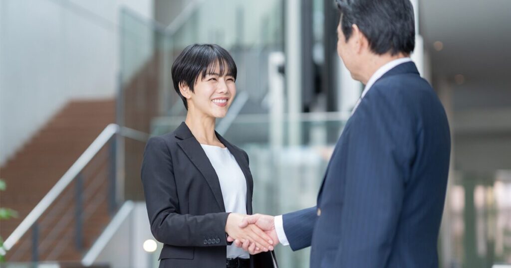 ビジネスシーンで上司が部下をねぎらい「ご苦労様です」と声をかけている様子
