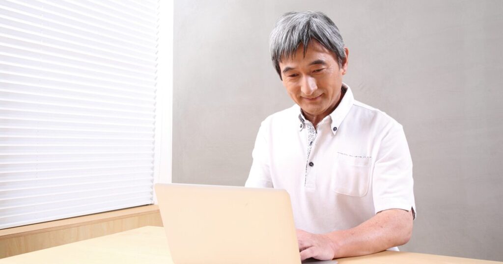 定年後の再就職に向けてパソコンで仕事を探すシニア男性