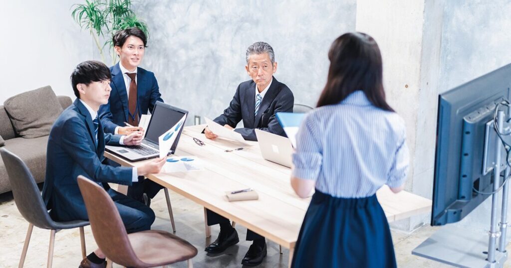 総務としてキャリアを積み、社内会議を進行している女性のイメージ