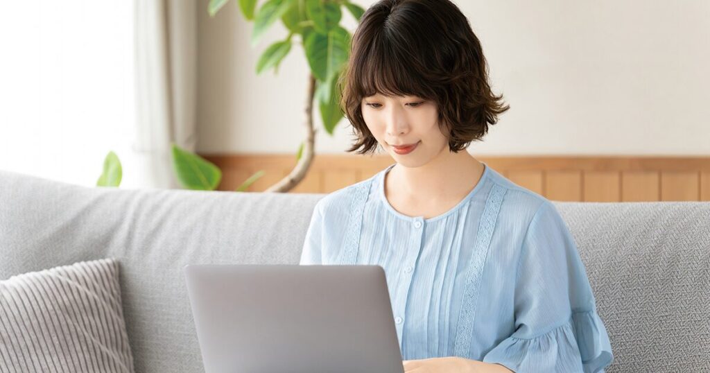 自宅のパソコンで確定申告の手続きをする派遣社員の女性