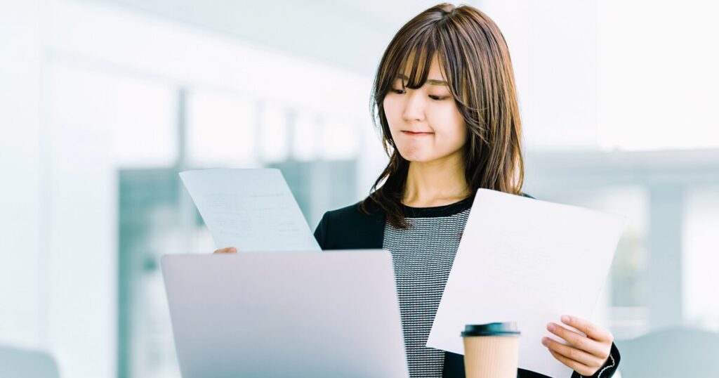 派遣の抵触日の対象条件を確認している女性