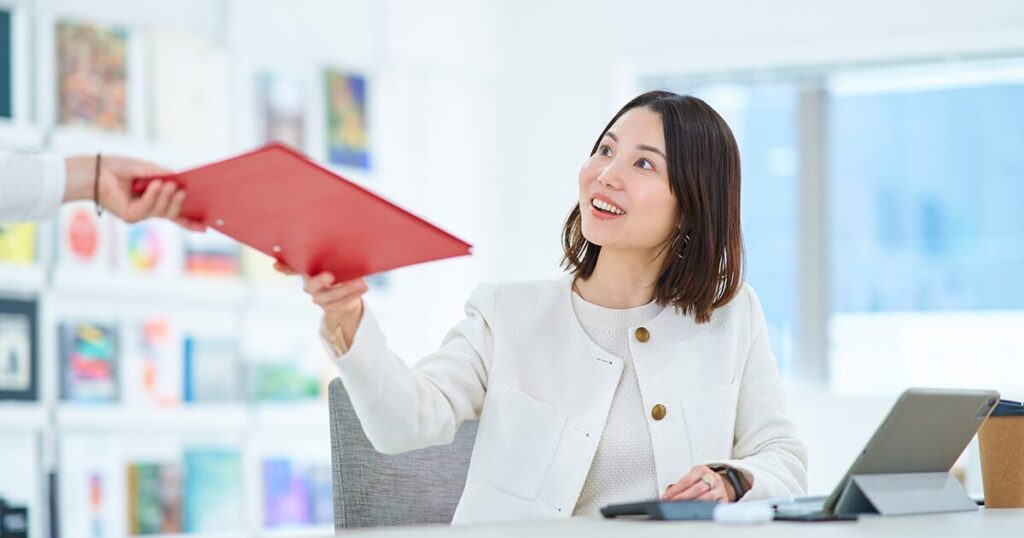 周囲とコミュニケーションを取りながら仕事をする庶務の女性